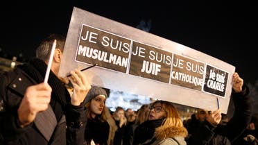 People hold a placard which reads “I am Muslim, I am Jewish, I am Catholic, I am Charlie” at a vigil in Paris January 8, 2015. (Reuters)