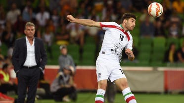  Iran's Alireza Jahan Bakhsh (R) heads the ball as coach Carlos Quieroz (L) looks on during their football match against Bahrain at the AFC Asian Cup in Melbourne on January 11, 2015.