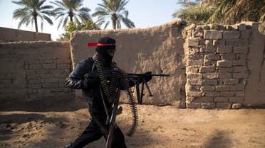 A fighter from the Shi'ite Kata'ib Imam Ali (Imam Ali Brigades) militia runs as they search a house after taking control of a village from