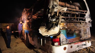 Pakistani volunteers search for victims inside a burnt out passenger bus after it collided with an oil tanker along the Super Highway near Karachi early on January 11, 2015. (AFP)