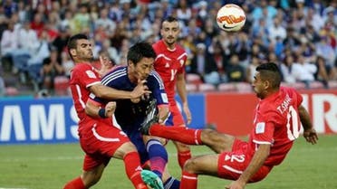 Japan’s Yohei Toyoda is tackled by Palestine's Musab Battat, left, and Tamer Salah, right, during the AFC Asia Cup soccer match between Japan and Palestine in Newcastle, Australia, Monday, January 12, 2014. (AP Photo/Rob Griffith)