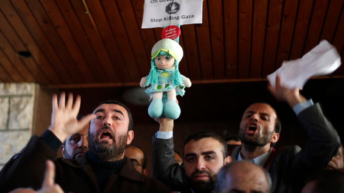 Palestinian Hamas-hired employees shout slogans after breaking past the gate of the Palestinian cabinet headquarters to demand their pay, in Gaza City January 13, 2015. Reuters
