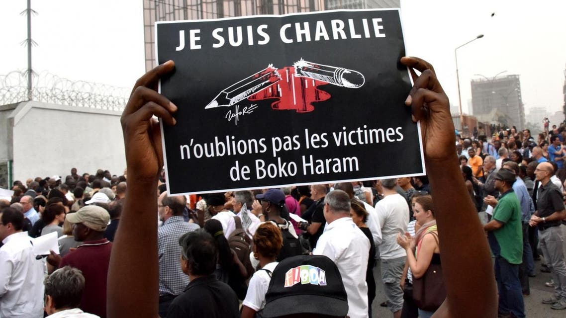 A man holds a placard that reads ‘I am Charlie, let’s not forget the victims of Boko Haram’ outside the French embassy in Abidjan. AFP