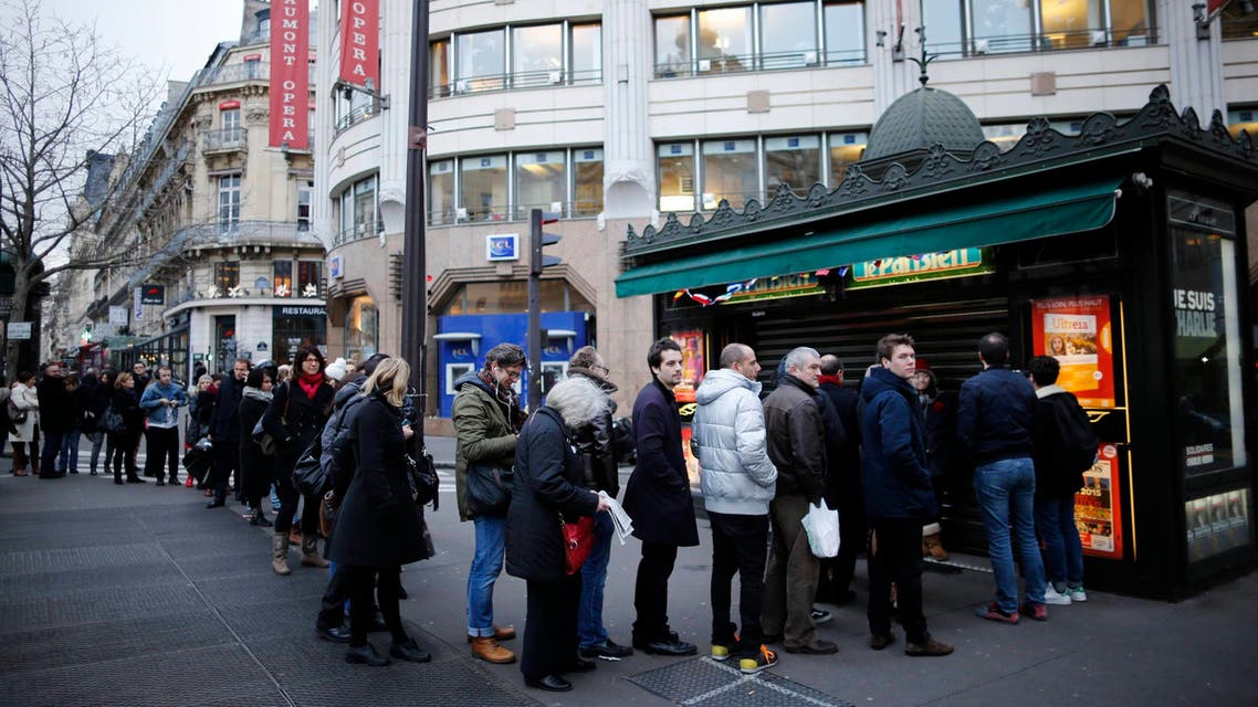 People queue to get a copy of satirical French magazine Charlie Hebdo new issue titled "Tout est pardonne" ("All is forgiven") showing a caricature of Prophet Mohammad in front of a kiosk in Paris Jan. 14, 2015. (Reuters)