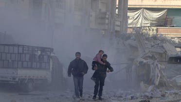 A man carries a girl past damage at a site hit by what activists said was an air strike by forces loyal to Syria's President Bashar al-Assad in the northwestern Homs district of Al Waer December 30, 2014. (Reuters) 