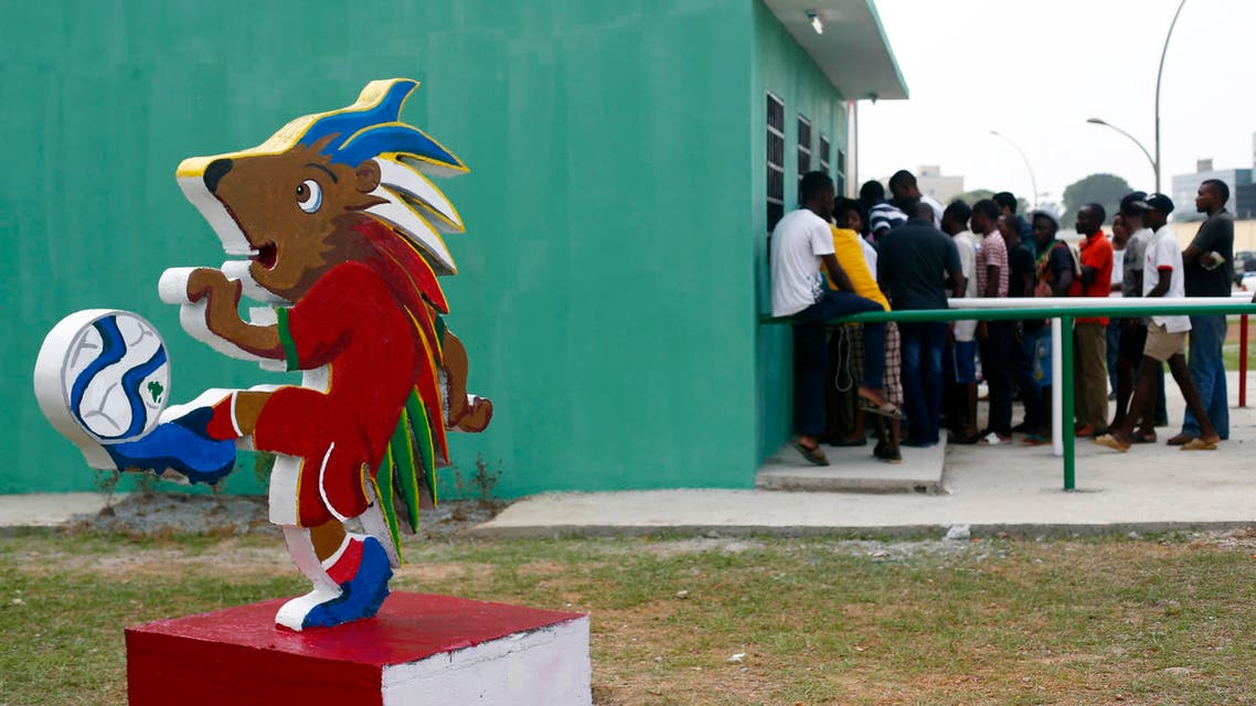Chuku Chuku, the official mascot of the tournament is seen as fans wait in line to buy tickets for the upcoming African Nations Cup outside the Estadio de Bata "Bata Stadium" which will host the opening ceremony on Saturday, in Bata Jan. 15, 2015. (Reuters)