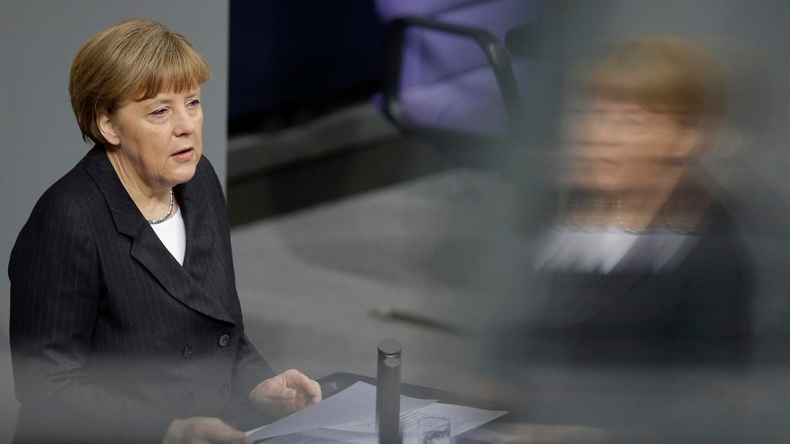 German Chancellor Angela Merkel is reflected in a window of the visitors' tribune as she speaks during a meeting of the German federal parliament, Bundestag, in Berlin, Germany, Thursday, Jan. 15, 2015. (AP)