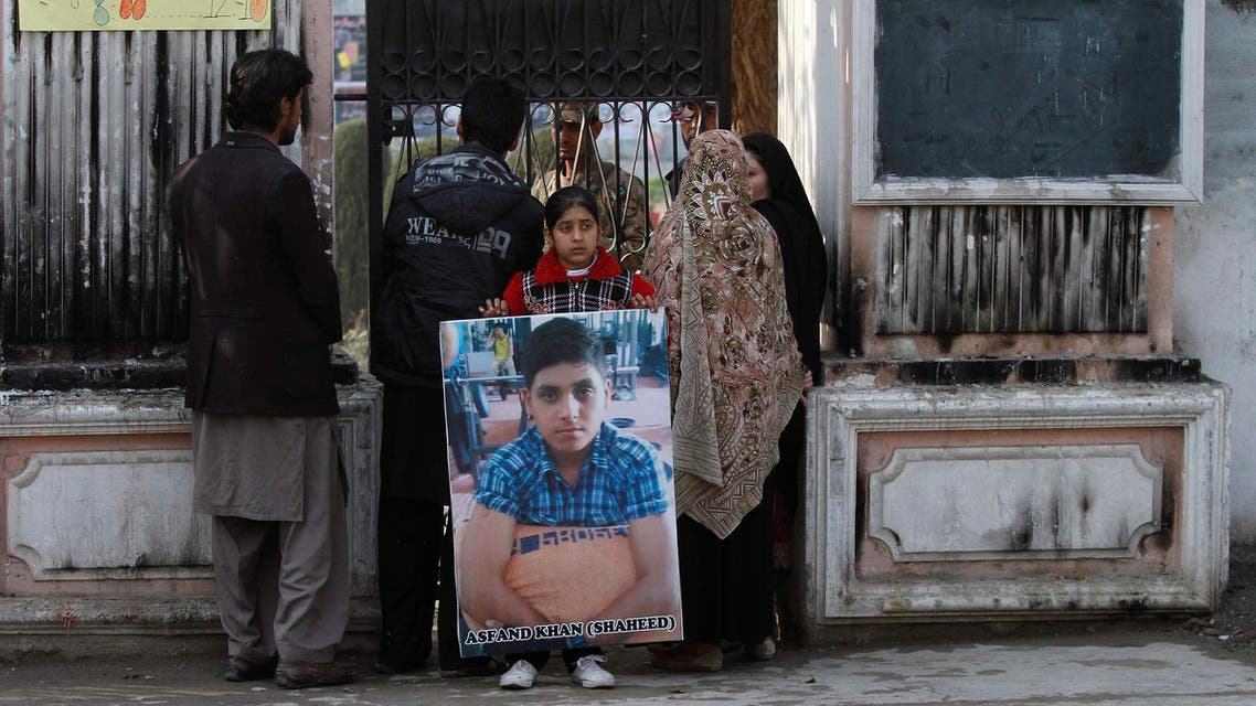 The sister of a student who was killed during an attack by Pakistan's Taliban gunmen carries his portrait while standing with her family members, in Peshawar January 14, 2015. (Reuters)