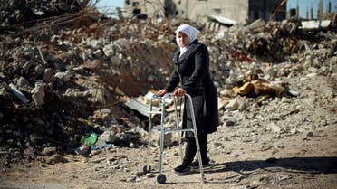 Palestinian girl Manar Al-Shinbari, 15, who lost her both legs by what medics said was Israeli shelling at a UN-run school where she was taking refuge during the 50-day war last summer, uses her walker near the ruins of her house that witnesses said was destroyed by Israeli shelling during the war, in Biet Hanoun in the northern Gaza Strip January 13, 2015. Reuters