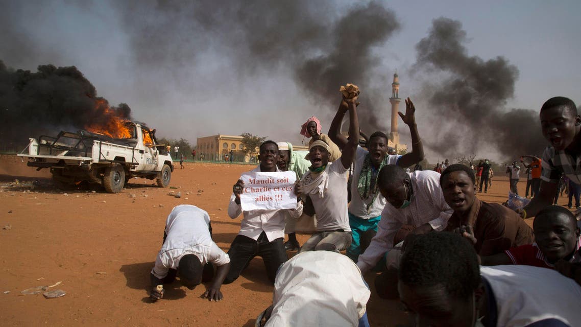 A man (2nd L) holds a sign reading Charlie and his Allies are Damned during a protest in Niger. (Reuters)