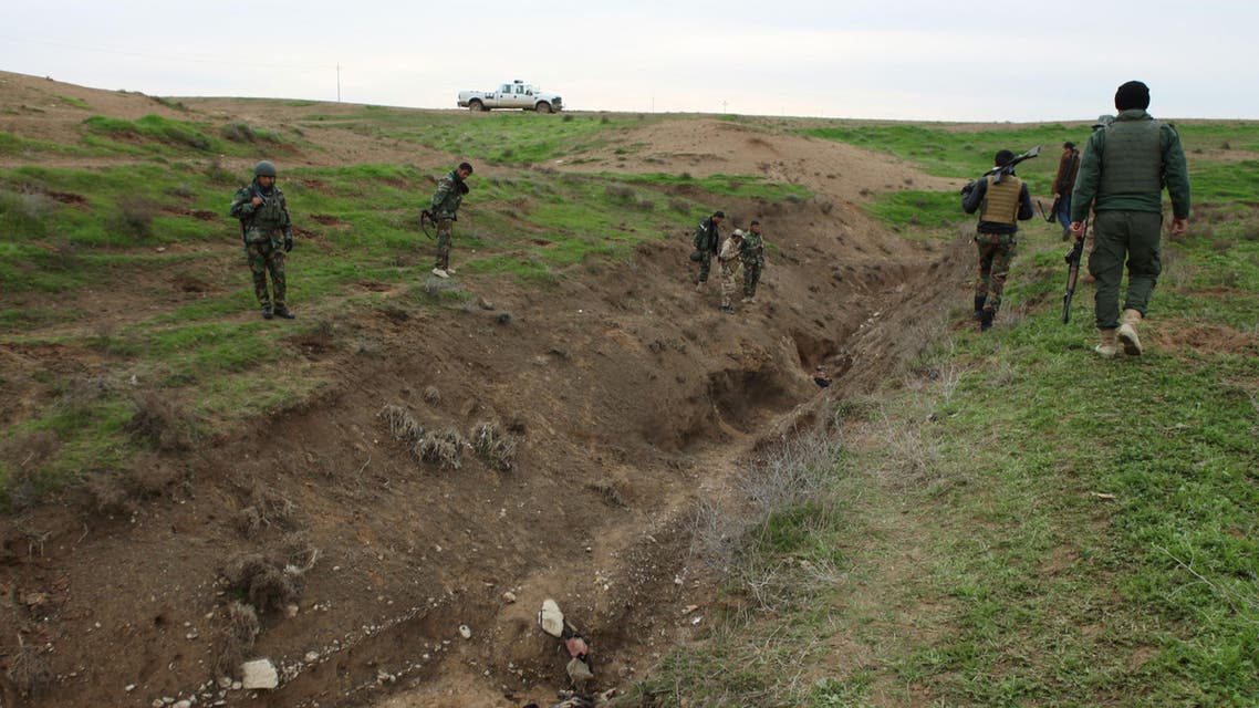 Iraqi Kurdish forces gather to see bodies of Islamic State militants killed during fighting on Wednesday, when Kurdish forces push towards Sinjar Mountain, as they inspect the area in Kobani, Iraq, Thursday, Dec. 18, 2014. (AP)
