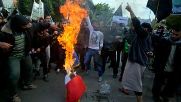 Palestinian Salafists, members of an ultraconservative sect of Islam, burn a French flag and chant angry slogans during a protest against caricatures of the Prophet Muhammad published in the satirical French weekly magazine Charlie Hebdo, outside the French Cultural Center in Gaza City, Monday, Jan. 19, 2015. (AP Photo)