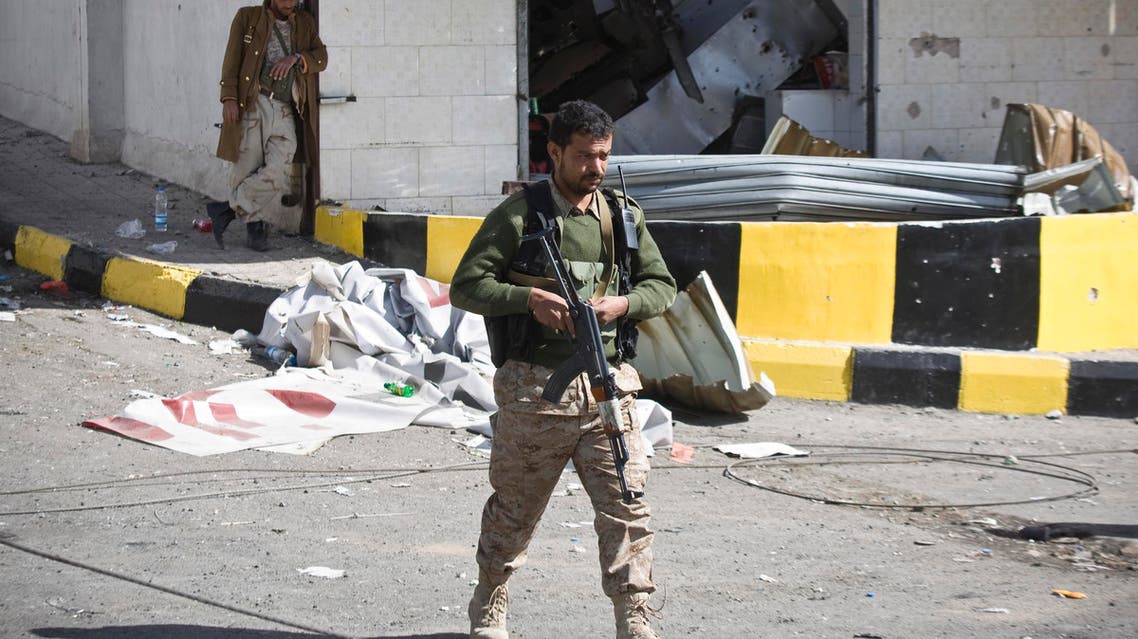 Houthi Shiite Yemeni wearing an army uniform stand guard in front of a building damaged during recent clashes near the presidential palace in Sanaa, Yemen, Tuesday, Jan. 20, 2015. AP