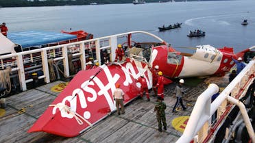 Crew members of Crest Onyx ship prepare to unload parts of AirAsia Flight 8501 from a ship at Kumai port in Pangkalan Bun,Sunday, Jan.11, 2015. AP