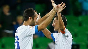 Uzbekistan's Vokhid Shodiev (L) celebrates with teammate Odil Akhmedov after winning in their Asian Cup Group B soccer match against Saudi Arabia at the Rectangular stadium in Melbourne Jan. 18, 2015. (Reuters)