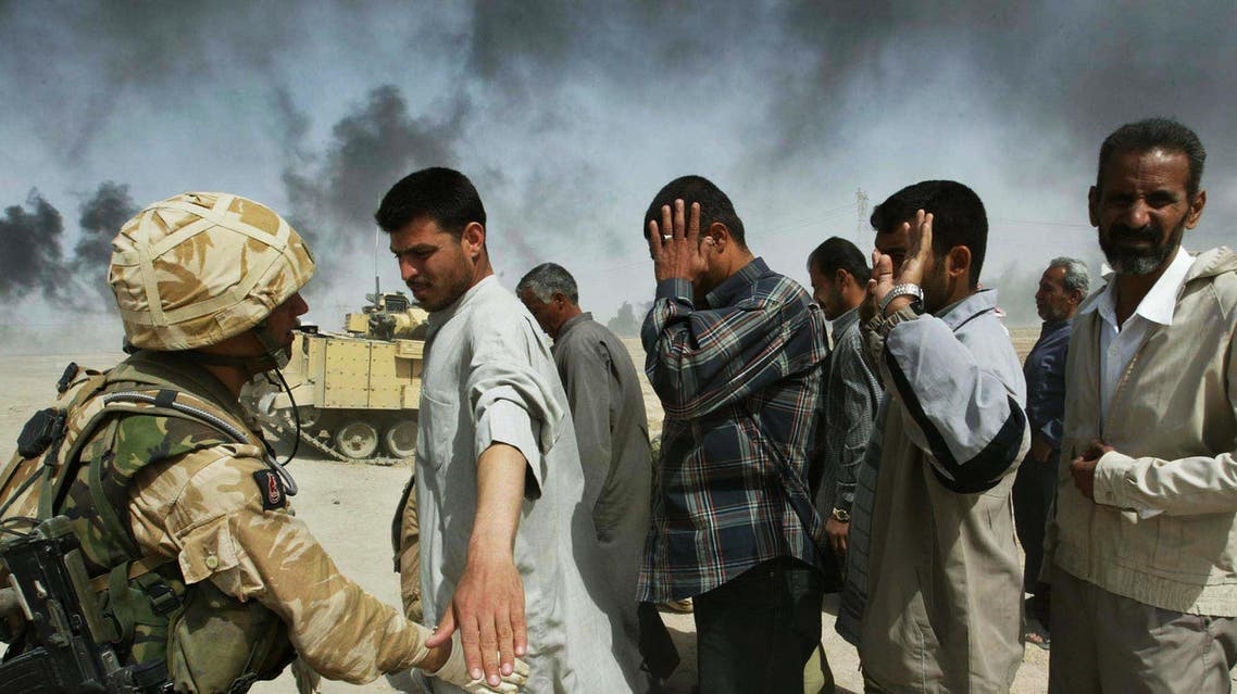 British soldiers check Iraqi men on the outskirts of Basra who are fleeing from this southern Iraqi town Tuesday, April 01, 2003. (AP Photo)