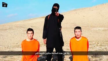 A masked person holding a knife speaks as he stands in between two kneeling men in this still image taken from an online video released by the militant Islamic State group on January 20, 2015. (Reuters)