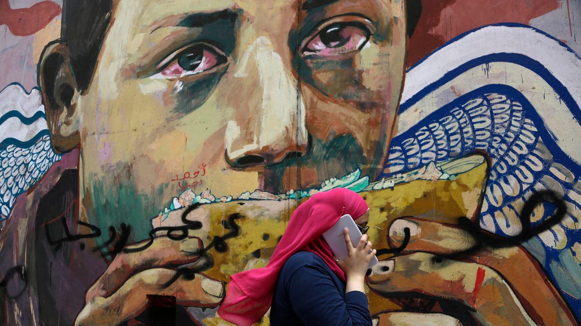 A woman talks on her tablet phone while walking past graffiti in Mohammed Mahmoud Street near Tahrir Square, in downtown Cairo, Egypt, Wednesday, Sept. 17, 2014. AP