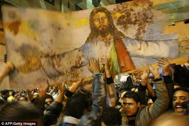 Spattered with blood: Christians carry a portrait of Christ taken from the bombed church of al-Qiddissian through the streets of Alexandria AFP