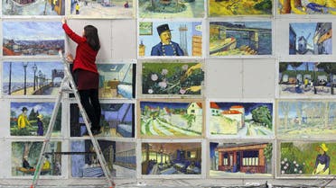 Joanna Maleszyk hangs up recreations of Vincent van Gogh paintings at a film studio in the northern Polish city of Gdansk on December 5, 2014. (AFP)