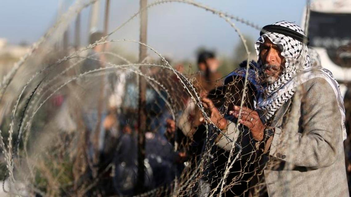 A Palestinian man, hoping to cross into Egypt, stands behind a fence as he waits for a travel permit at the Rafah crossing between Egypt and the southern Gaza Strip January 22, 2015. reuters