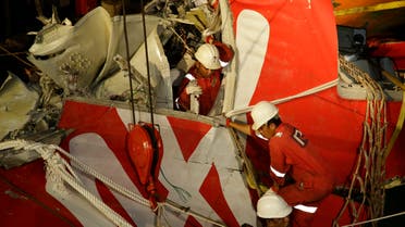 Crew members of Crest Onyx ship unload the wreckage of part of the ill-fated AirAsia Flight 8501 crashed off the Java Sea, at Kumai port in Pangkalan Bun, Indonesia, Sunday, Jan. 11, 2015. AP