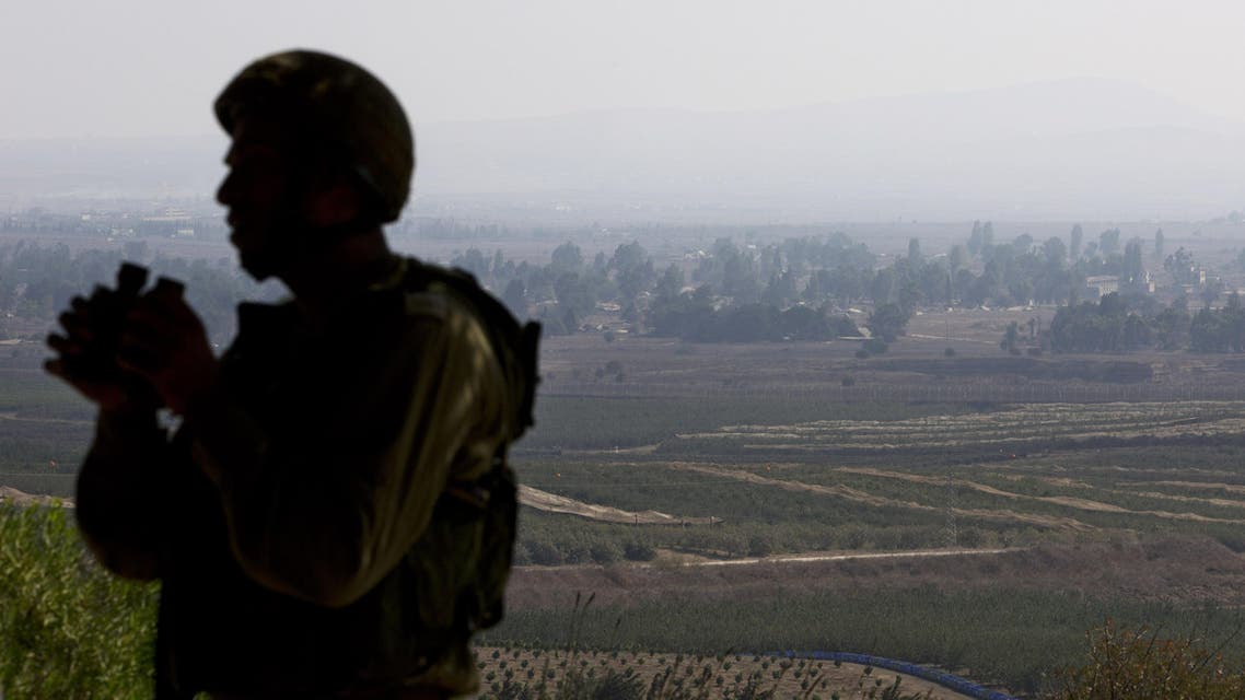 Israeli soldier overlooks Syria's Quneitra from Golan Heights AP