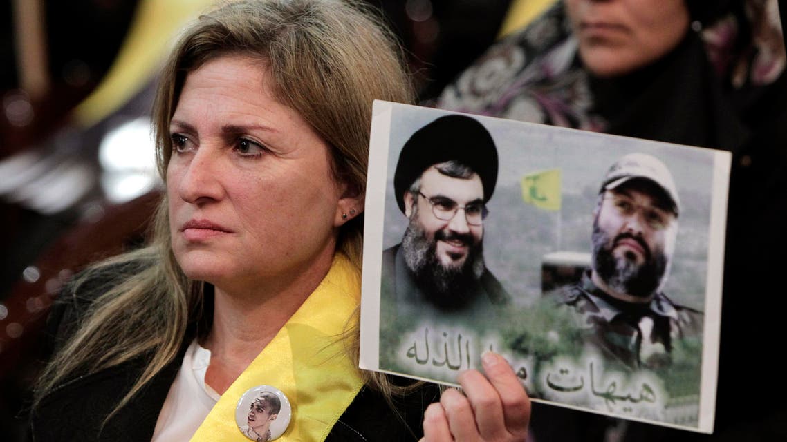 A Hezbollah supporter holds up a portrait of late Hezbollah military commander Imad Mughniyeh, right, and Hezbollah leader Sheikh Hassan Nasrallah, during a ceremony marking the death of six Hezbollah fighters, including the son of Mughniyeh, and an Iranian general who were killed in an Israeli airstrike in Syria’s Golan Heights last week, in the southern suburb of Beirut, Lebanon, Friday, Jan. 30, 2015. AP