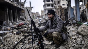 Musa, a 25-year-old Kurdish marksman, sits in the rubble of the Syrian town of Kobane, also known as Ain al-Arab, on January 30, 2015. AFP