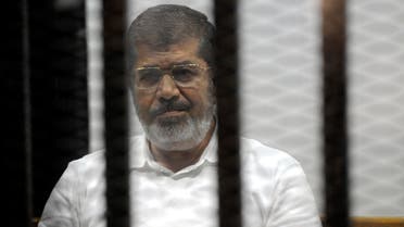 Egypt's ousted Islamist President Mohammed Morsi sits in the defendant cage in the Police Academy courthouse during a court hearing on charges of inciting the murder of his opponents, in Cairo, Egypt, Monday, Nov. 3, 2014. (AP)
