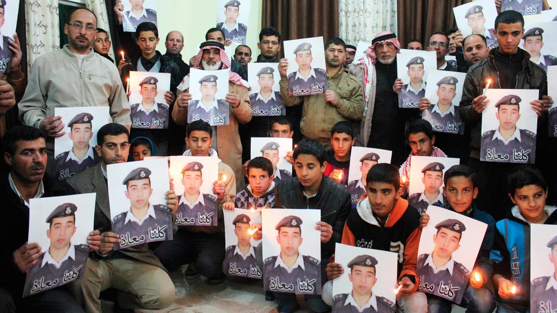 Relatives of ISIS captive Jordanian pilot Muath al-Kasaesbeh hold his portrait as they take part in a rally in his support at the family's headquarters in the city of Karak, January 31, 2015. (Reuters)