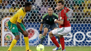 South Africa's Siyabonga Sangweni, left, scores past Morocco's Abderrahim Achchakir, right, and goalkeeper Nadir Lamyaghri in their African Cup of Nations Group A soccer match, in Durban, South Africa, Sunday, Jan. 27, 2013. (AP)