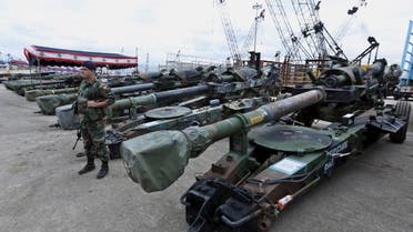 A Lebanese army soldier stands next to artillery pieces that were unloaded from a ship at Beirut's port in Lebanon on Sunday, Feb. 8, 2015. (AP)