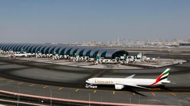 A plane passes next to the Emirates Airlines terminal at the concourse in Dubai International Airport, Jan. 7, 2013. (AFP)