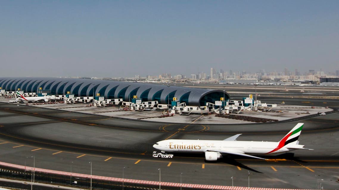 A plane passes next to the Emirates Airlines terminal at the concourse in Dubai International Airport, Jan. 7, 2013. (AFP)