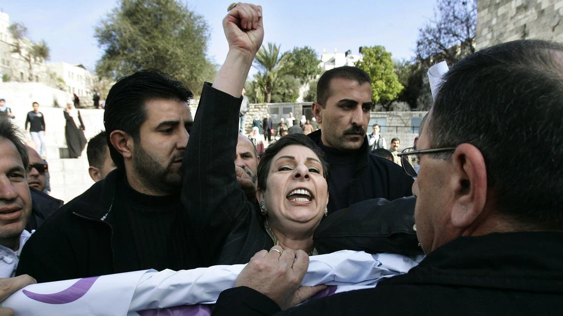 Palestinian parliamentary election candidate Hanan Ashrawi, center, from the Third Way party shouts as she and supporters scuffle with Israeli police officers, right, as they take her election banner from her during a campaign stop in front of Damascus Gate in Jerusalem's Old City, Tuesday, Jan. 3, 2006. AP