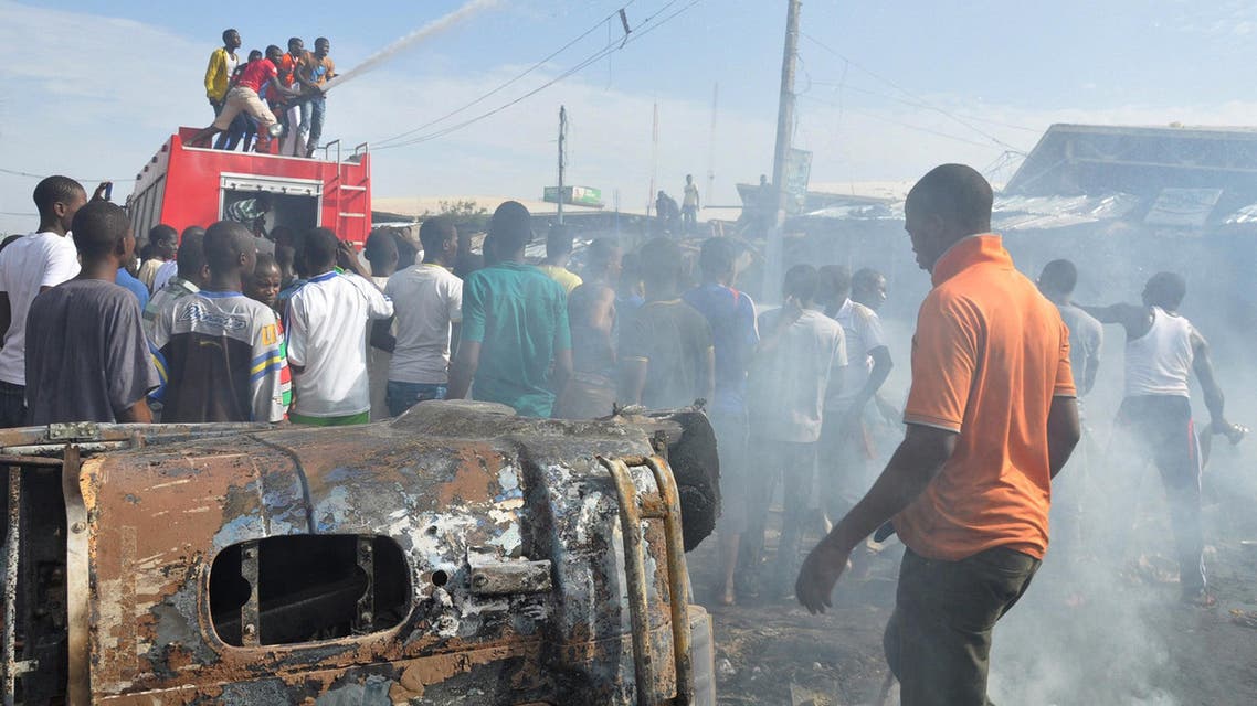 In this Tuesday, July , 2014 file photo, People gather at the scene of a car bomb explosion, at the central market, in Maiduguri, Nigeria. AP
