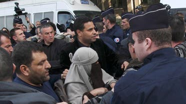 An unidentified veiled woman is taken away by plain clothed and uniformed police officers, flanked by a friend, center right, in Paris Monday, April 11, 2011. AP
