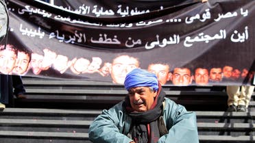 A family member of one of  Egyptian Coptic Christian workers who have been kidnapped in the Libyan city of Sirte, sits crying in front of a banner with pictures of the workers, in Cairo, Feb. 13, 2015. (Reuters)