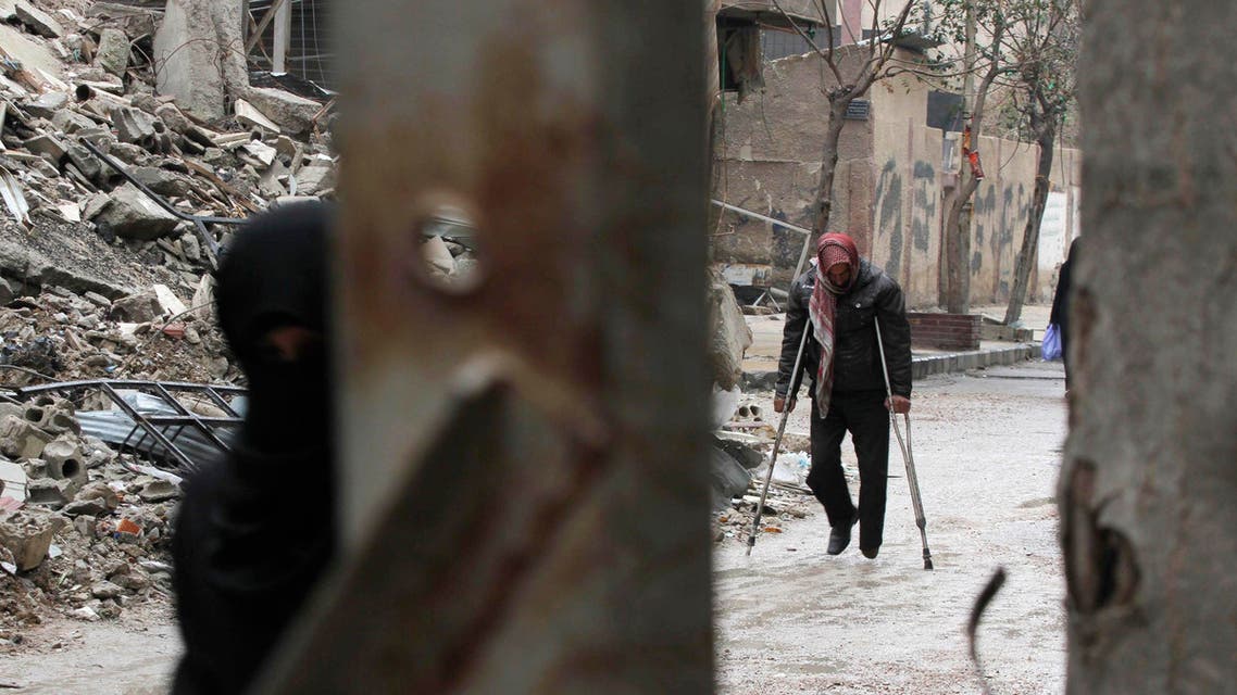 A man walks on crutches near the rubble of collapsed buildings in the Douma neighbourhood of Damascus February 12, 2015. (Reuters)