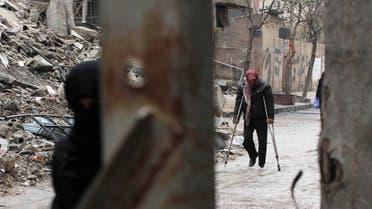 A man walks on crutches near the rubble of collapsed buildings in the Douma neighbourhood of Damascus February 12, 2015. (Reuters)