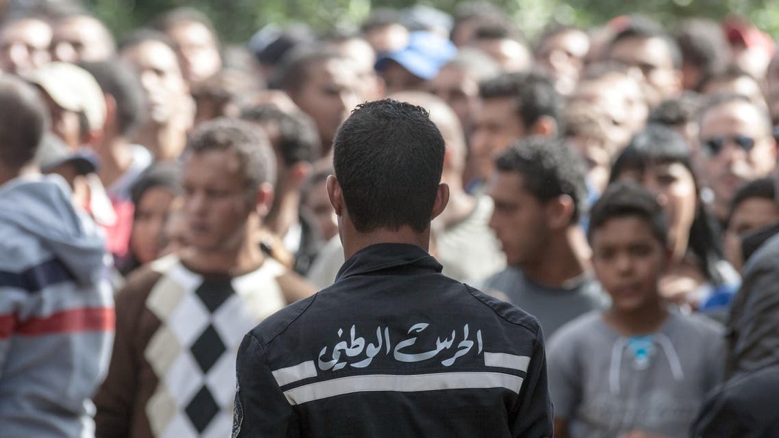 A member of the National Guard prevents onlookers from approaching the scene of a shooting between soldiers and gunmen in the Oued Ellil suburb of Tunis, Tunisia, Friday, Oct. 24, 2014. AP