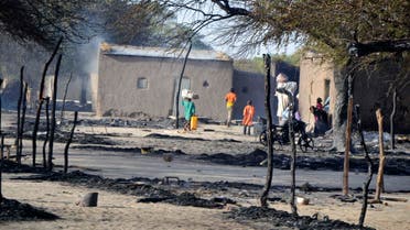 People walk in a burnt compound after an attack by Boko Haram militants in the village of Ngouboua Feb. 13, 2015. (Reuters)