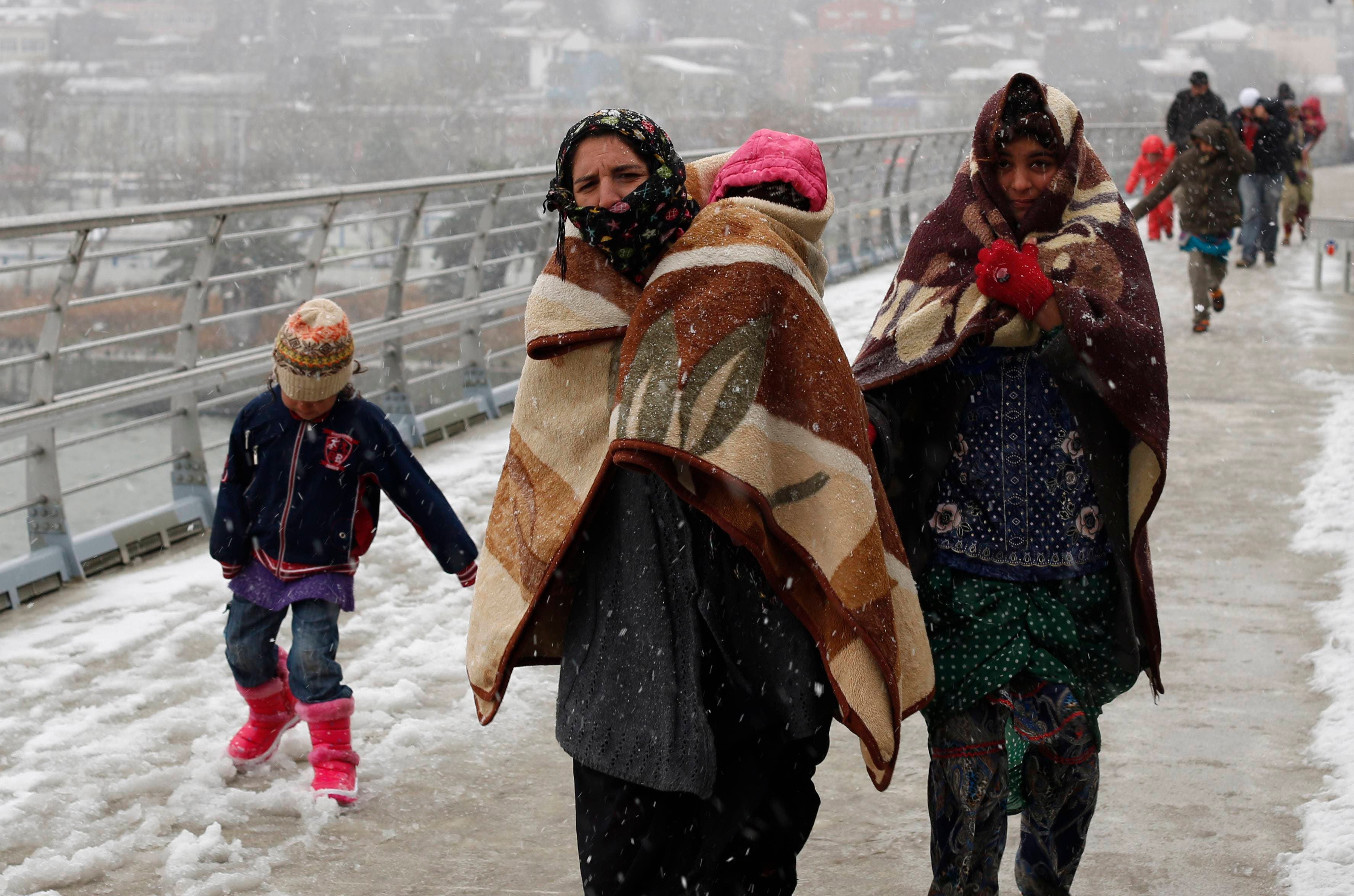 Syrian refugees brave the cold and snow as they walk to a metro station in Istanbul February 11, 2015, at the start of a day’s begging. (Reuters)