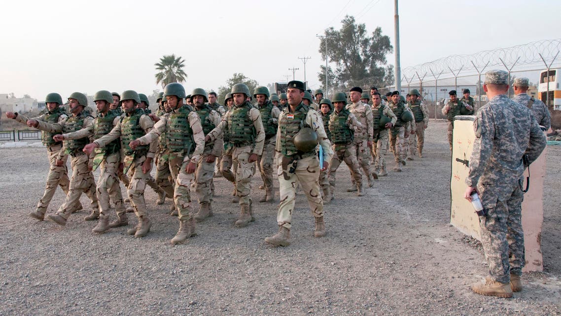 In this Thursday, Feb. 13, 2015 photo released by the U.S. Army, U.S. Army soldiers from the 1st Infantry Division, based at Fort Riley, Kansas, watch as Iraqi army soldiers with the 72nd Brigade march at Camp Taji, north of Baghdad, Iraq.(AP)