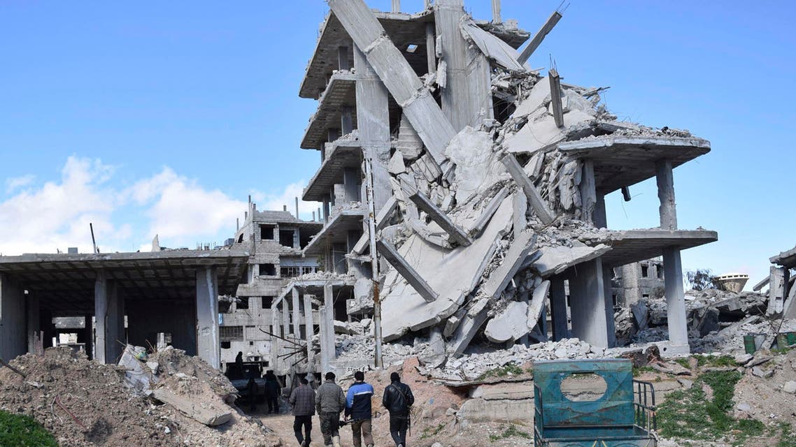 Rebel fighters from the Free Syrian Army's Al Rahman legion walk past a damaged building near the frontline against forces loyal to Syria's President Bashar al-Assad in the besieged town of Arbeen in the eastern Ghouta of Damascus February 19, 2015. (Reuters)