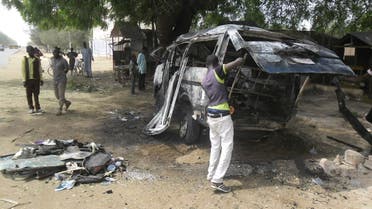 A man inspects a bus following an explosion on the street in Potiskum, Nigeria. Tuesday, Feb. 24, 2015 . AP