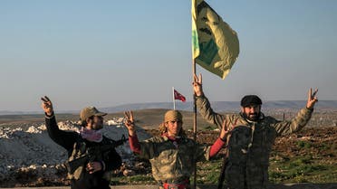 Syrian Kurdish militia members of YPG make V-sign next to poster of Abdullah Ocalan, jailed Kurdish rebel leader, and a Turkish army tank in the background in Esme village in Aleppo province, Syria, Sunday, Feb. 22, 2015. (AP)