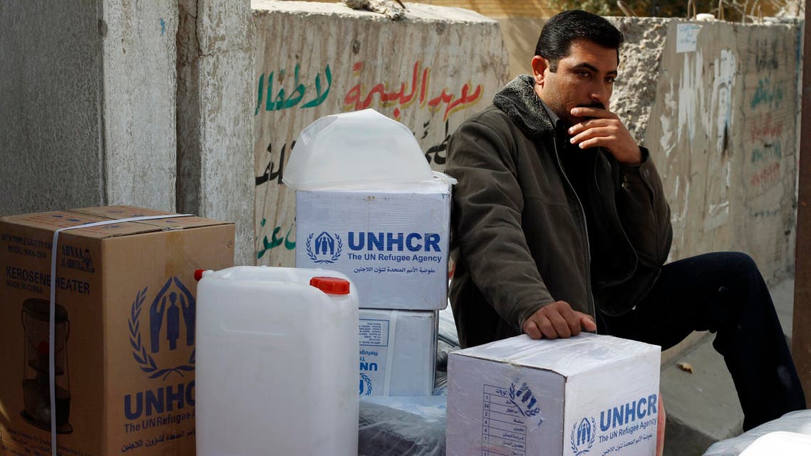 A displaced Iraqi Sunni man fleeing from ISIS militants in al-Baghdadi district in Anbar provinces, sits beside aid received from the UNHCR in Baghdad February 24, 2015. (Reuters)