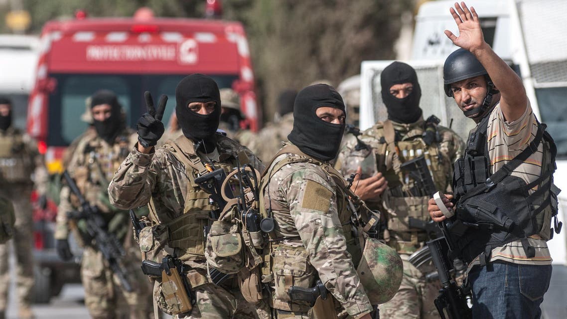 Tunisian soldiers celebrate at the end of a successful raid against gunmen in the Oued Ellil suburb of Tunis, Tunisia, Friday, Oct. 24, 2014. AP